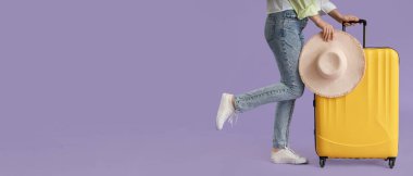 Bavulu ve eflatun kaplamalı şapkası olan, mesaj için yeri olan genç bir kadın. Seyahat kavramı