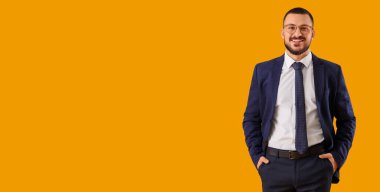 Sarı arka planda takım elbiseli genç işadamı, mesaj için yeri var.