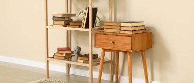 Oturma odasının içinde kitap olan ahşap masa ve raflar.