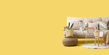 Ev bitkileriyle rahat bir kanepe ve sarı arka planda mesaj için yeri olan bir puf.