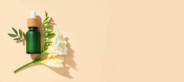 Bej arkaplanda bir şişe temel yağ ve frezya, metin için boşluk, üst görünüm