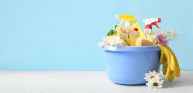 Temizlik malzemeleri ve bahar çiçekleri metin için alanı olan renk arkaplan üzerinde