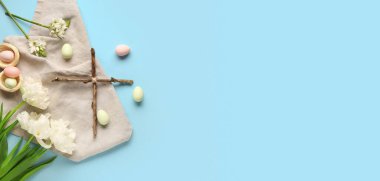Çapraz, Paskalya yumurtaları ve çiçekler açık mavi arkaplanda metin için boşluk, üst görünüm