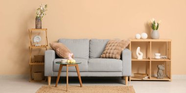 Paskalya için gri kanepeyle dekore edilmiş oturma odasının içi.