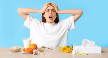 Stresli genç bir kadın ve mavi arka planda farklı alerjiler.