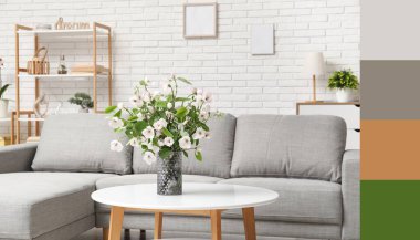 Gri kanepesi, masası ve çiçek açan ağaç dallarıyla dolu vazosu olan aydınlık oturma odası. Farklı renk desenleri