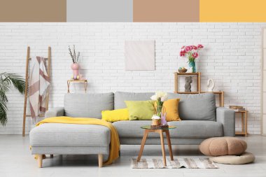 Aydınlık oturma odasının içinde gri kanepe, cam masa ve Paskalya süslemeleri var. Farklı renk desenleri