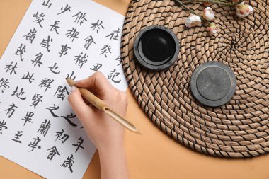 Renkli arka plana Asya hiyeroglifleri yazan bir kadın. Uluslararası Haiku Şiir Günü