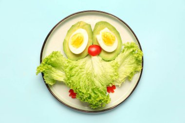 Mavi arka planda baykuş şeklinde komik bir kahvaltı tabağı.