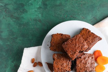 Yeşil arka planda lezzetli çikolatalı brownie parçaları olan tahta.