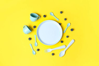 Sarı arka planda bebek için farklı yemek tabakları