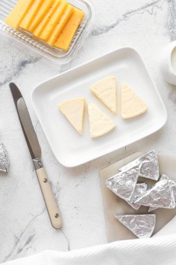 Açık arkaplanda lezzetli işlenmiş peynir üçgenleri olan tabak