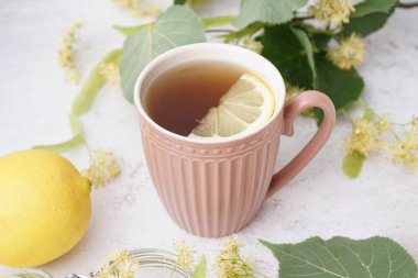 Beyaz arka planda limonlu ıhlamur çayı.