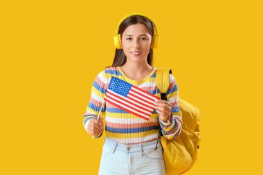 Sarı arka planda Amerikan bayrağı olan bayan öğrenci.