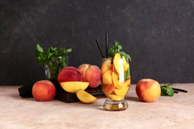 Bir bardak taze şeftalili limonata, üzerinde de nane şekeri.