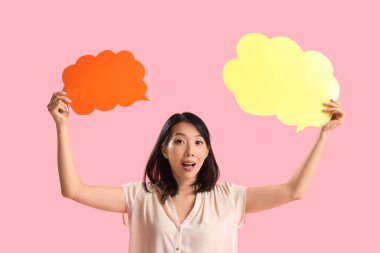 Pembe arka planda boş konuşma baloncukları olan güzel Asyalı kadın.