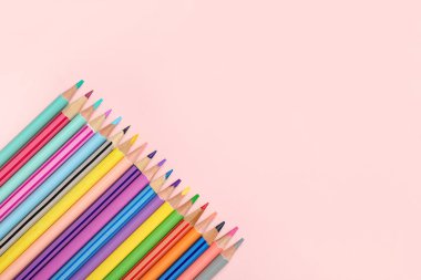 Pembe bir arka plan üzerinde renkli kalemler