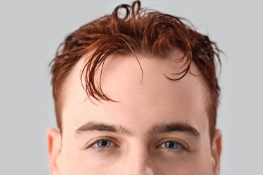 Açık arkaplanda ıslak saçlı genç bir adam.