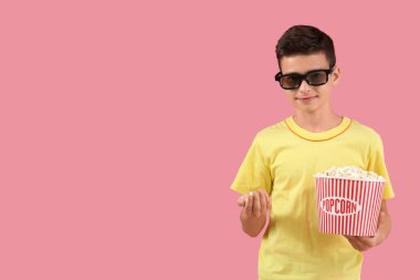 Pembe arka planda patlamış mısırlı 3 boyutlu gözlüklü şirin bir çocuk.