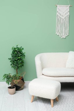 Beyaz kanepe, kanepe ve çiçeklerle modern oturma odasının içinde.