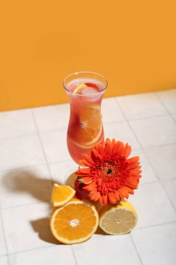 Sarı duvarın yanında çilek, limon, portakal ve çiçekli narenciye kokteyli.