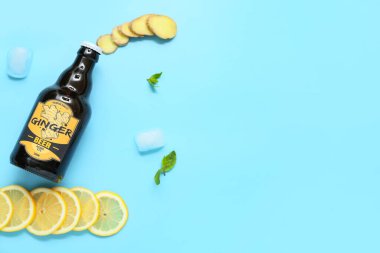 Taze zencefilli bira, nane şekeri, limon dilimleri ve mavi arka planda buz küpleriyle kompozisyon