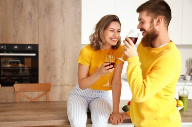 Aşık mutlu çift mutfakta şarap içiyor.