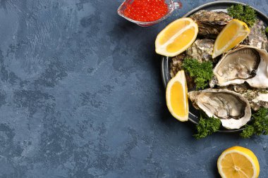 Lezzetli istiridye tabağı ve mavi arka planda kırmızı havyar.