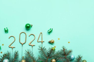 Noel süslemeleri ve turkuaz arka planda köknar dalları olan kıvılcımlardan yapılmış figür 2024