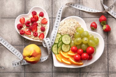 Taze sağlıklı ürünleri olan tabaklar ve gri fayansların üzerindeki şerit. Diyet kavramı