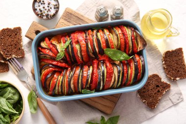 Beyaz arka planda lezzetli Ratatouille, ekmek, yağ ve baharatlar pişirmek.