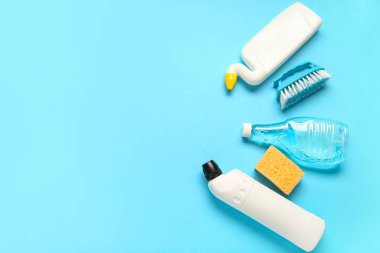 Mavi arka planda deterjan ve sünger şişeleri