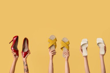 Sarı arka planda farklı şık ayakkabılar giyen kadınlar.