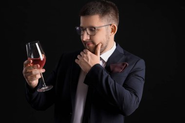 Siyah arka planda şarap kadehi olan genç şarap garsonu.