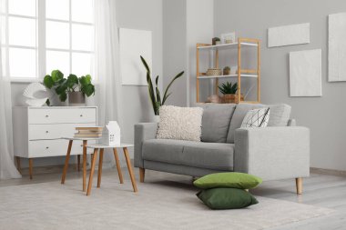 Grey sofa with cushions in interior of modern living room