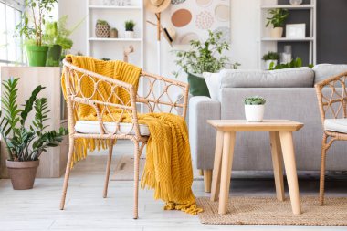 Koltuğu, gri koltuğu ve çiçekleri olan modern oturma odasının içinde.