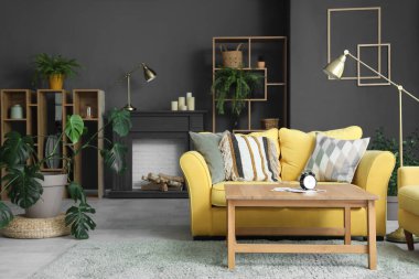 Dekoratif şömine rafı ve kanepesi olan oturma odasının içinde.