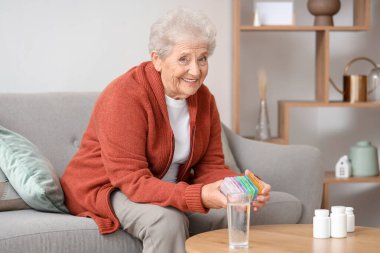 Evde hap kutusu olan son sınıf öğrencisi bir kadın.