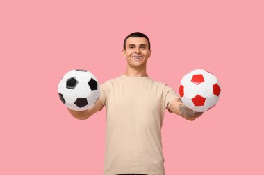 Pembe arka planda futbol topu olan yakışıklı genç adam.