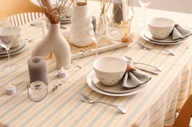 Katlanmış peçeteler, kaseler ve çatal bıçaklarla şık bir masa.