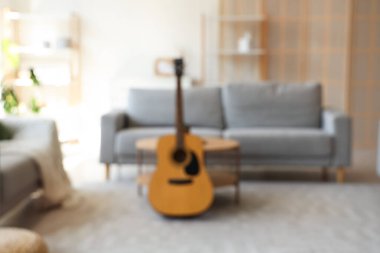 Oturma odasının bulanık görüntüsü gitar, masa ve kanepelerle