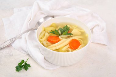 Beyaz arka planda bir kase lezzetli tavuk çorbası.