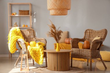 Sehpanın üzerinde hasır koltuklar, balkabakları ve pampalar olan sonbahar içleri.