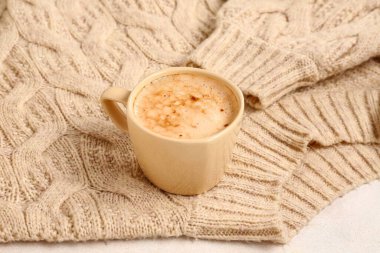 Masada bir fincan kahve ve kazak.