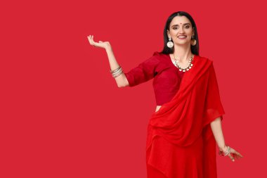 Kırmızı arka planda sarili güzel bir Hintli kadın. Divaly kutlaması