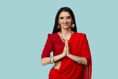 Sarili genç ve güzel bir Hintli kadın mavi arka planda dua ediyor. Divaly kutlaması