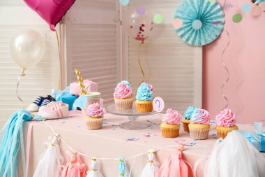 Bebek poposu ve masa üzerinde pembe arka planda süslemeleri olan enfes kekler. Cinsiyet ortaya çıkan parti kavramı