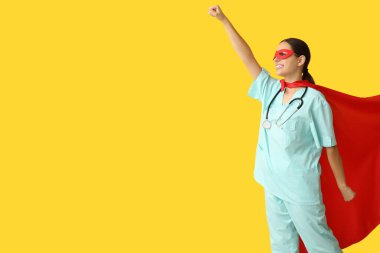 Sarı arka planda süper kahraman kostümlü güzel bayan doktor.