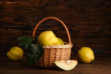 Tatlı olgun bıldırcınlar ve ahşap arka planda yapraklarla dolu bir sepet.