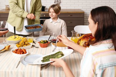 Şükran Günü 'nde mutlu bir aile şenlik masasında yemek yiyor.